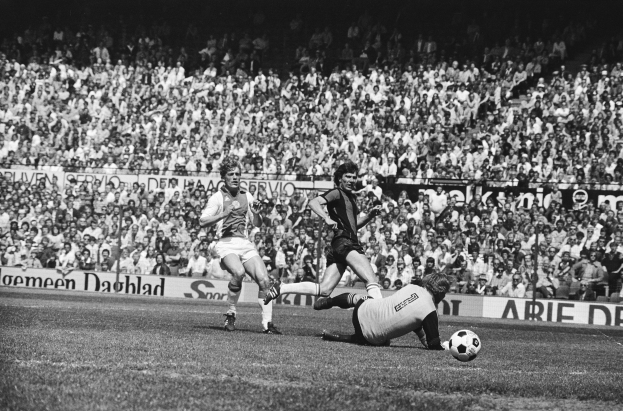 Schwarzes und weißes Foto von Fussballspielern im Einsatz auf einem Feld mit Zuschauern im Hintergrund und einer Bundesliga 1978-79 Ajax 1-1 Hannover 96-Tafel.