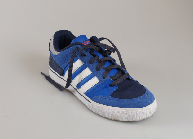 Ein Paar blaue und weiße Adidas-Schuhe mit blauen Oberteilen, weißen Akzenten, weißen Zwischensohlen, blauen Außensohlen, weißen Schnürsenkeln und einer blauen Zunge mit einem weißen Adidas-Logo, dargestellt auf einem weißen Hintergrund.