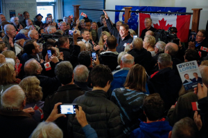 Eine Menschenmenge mit Kameras, Handys, Fahnen und Schildern steht vor einer Wand mit einem Fenster und einer Tür, mit einem Schild, auf dem steht "Loren Loren, der Vorsitzende der Liberalen Partei, wird von Unterstützern bei einer Wahlveranstaltung in Ottawa, Ontario, am Dienstag, dem 21. Januar 2020, begrüßt."