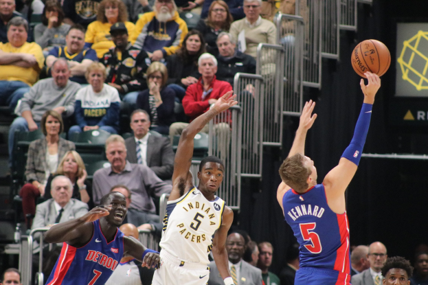 Basketballspiel zwischen den Indiana Pacers und den Detroit Pistons mit Zuschauern in den Rängen, einem Geländer im Hintergrund und einer Anzeigetafel rechts.