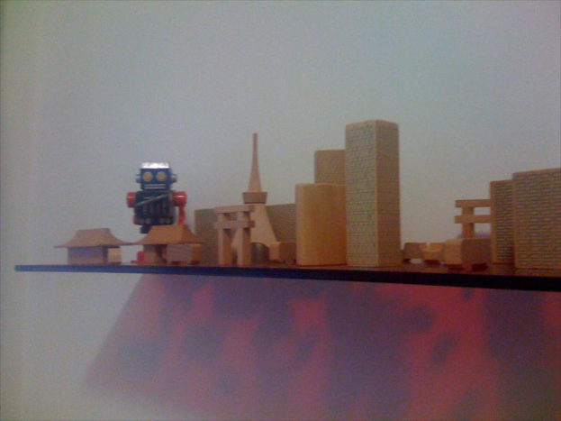 Eine Vielfalt an Spielzeugen ist auf einem Holzregal ausgestellt.