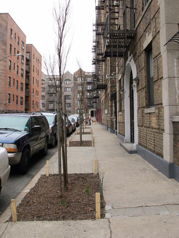 Eine spärlich bebaute Stadtkulisse mit wenigen Autos und Gebäuden in der rechten Ecke und einigen anderen Gebäuden in der linken Ecke.