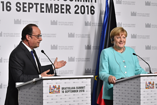 Bundeskanzlerin Angela Merkel und Frankreichs Präsident François Hollande stehen an Rednerpulten mit Mikrofonen, lächeln, mit einem 'Bratislava-Gipfel 2016'-Banner im Hintergrund.