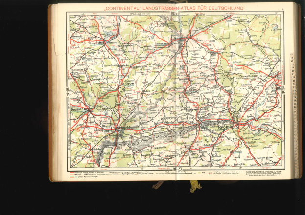 Offenes Buch mit detaillierter Karte von Deutschlands Straßen und Autobahnen auf schwarzem Hintergrund.