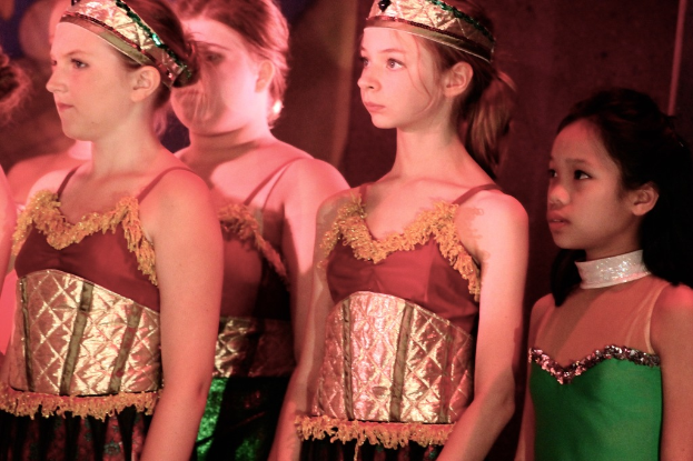 Mädchen in der Mitte, kostümiert und mit Kronen