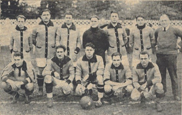 Schwarzes und weißes Foto einer Fußballmannschaft mit einigen stehenden und anderen im Schneidersitz sitzenden Mitgliedern, mit Text unten.