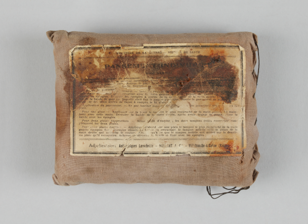 Eine kleine Tasche mit einem Stück Papier darauf, wahrscheinlich ein Verbandskasten, mit Text darauf.