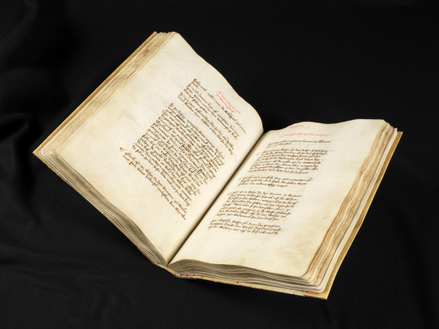 Ein aufgeschlagenes Buch mit rotem Text auf schwarzen Seiten.