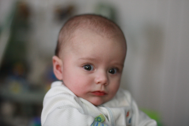 Ein Kind das vor einem unscharfen Hintergrund steht.