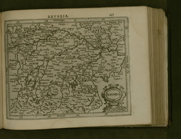 Offenes Buch mit detaillierter Karte von Bayern mit beschrifteten Städten und Dörfern sowie begleitendem Text.