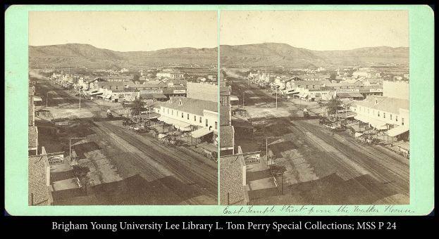 Ein Schwarz-Weiß-Foto einer Kleinstadt mit Gebäuden, Straßen, Masten, Bäumen und Bergen im Hintergrund, mit Text unten: "brigham young university lee library l tom perry special collections, miss p 24".