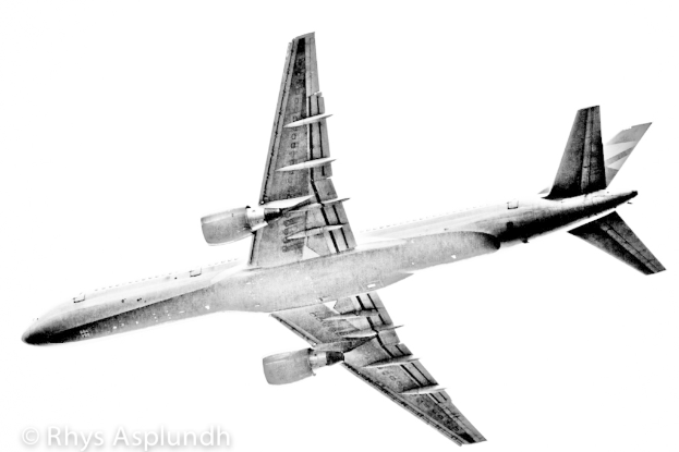 Ein Flugzeug, das am Himmel fliegt mit Text in der unteren linken Ecke.