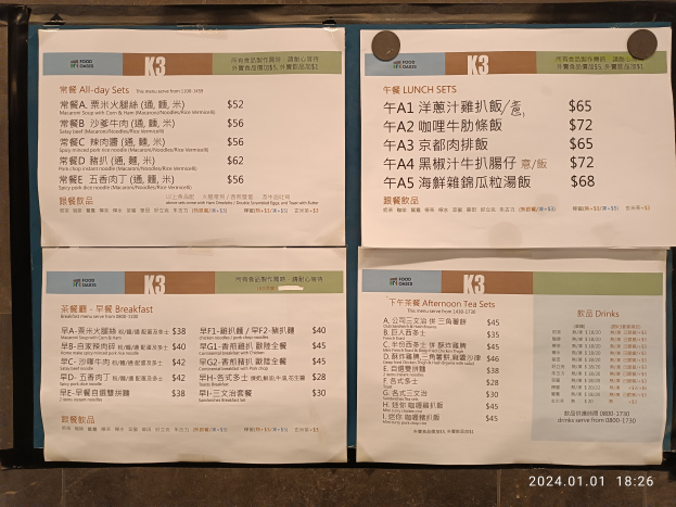 Ein Speisekarten-Schild an der Wand mit chinesischer Schrift, das verschiedene Gerichte und ihre Preise anzeigt.