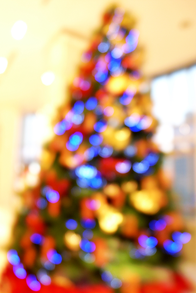 Ein unscharfer Bild eines Indoor-Weihnachtsbaums, der mit Lichtern und Schmuck geschmückt ist.