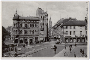 Altes Schwarz-Weiß-Foto einer belebten Münchner Stadtstraße mit Fußgängern, Fahrzeugen und Fenstern an den Gebäuden, Bäumen im Hintergrund und Text unten.