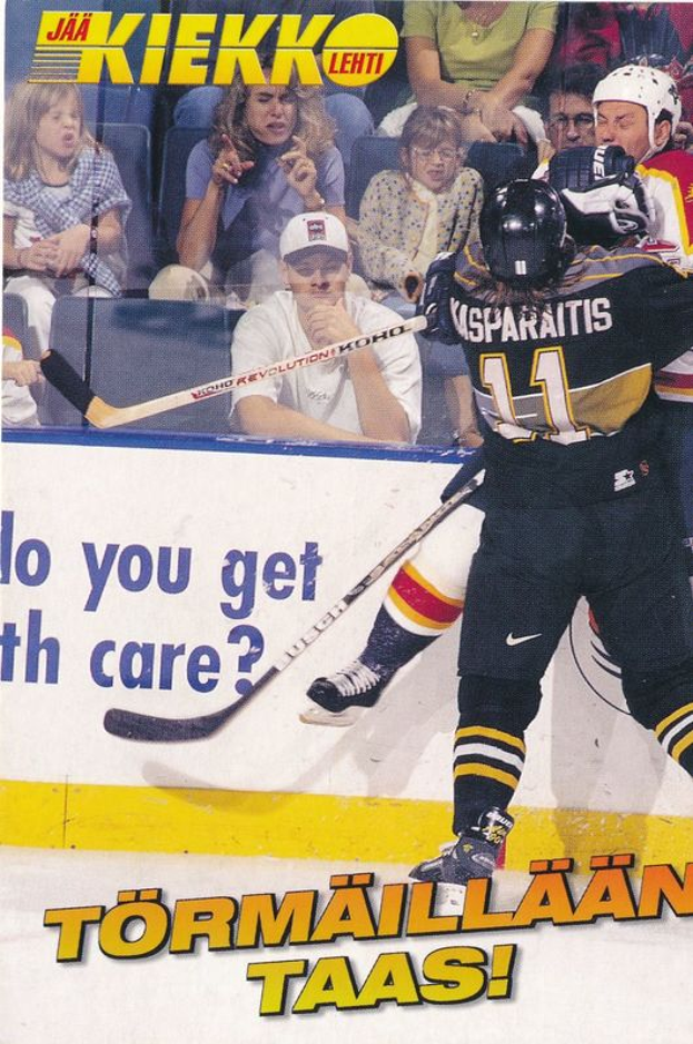 Ein Eishockeyspieler in Aktion auf dem Eis, der einen Helm tr├Ągt und einen Hockeystock in der Hand h├Ąlt, mit ein paar Menschen im Hintergrund und Text am unteren Rand des Bildes.