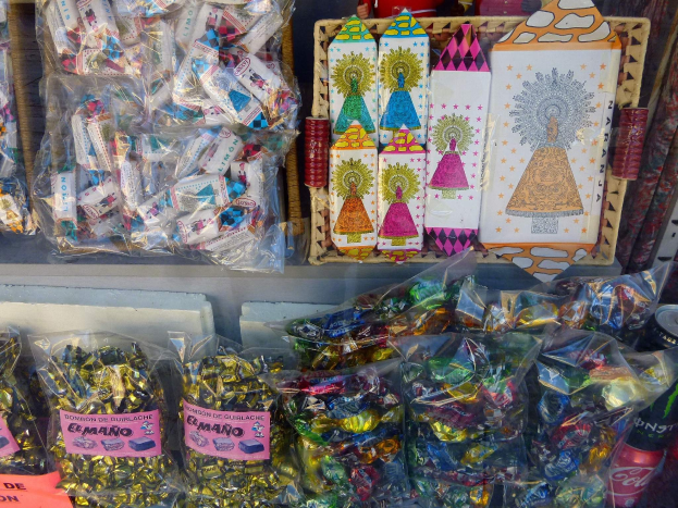 Vitrine mit verschiedenen Süßigkeiten, darunter Schokoladenpackungen, Flaschen und andere Gegenstände.