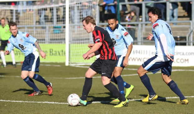 Eine Gruppe von Menschen, die mit einem Fußball auf einem Feld spielen.
