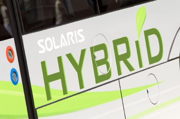 Nahaufnahme eines weißen und grünen Solaris Hybrid-E-Busses.