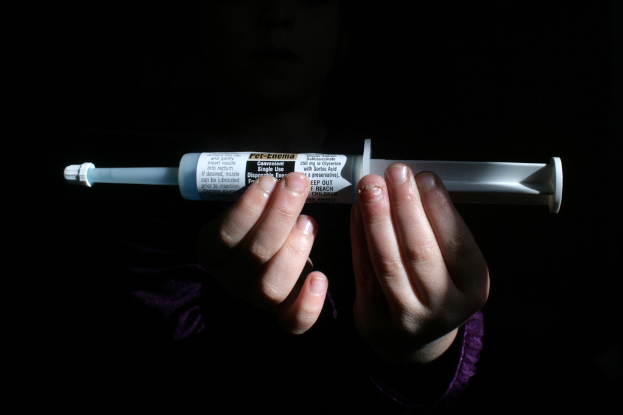 Eine Person hält eine Spritze mit Text darauf.