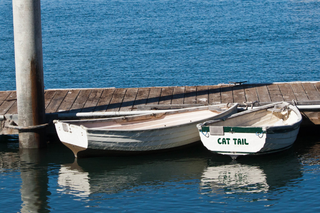 Zwei Boote auf einem Fluss mit einem Pfahl und einem Weg.