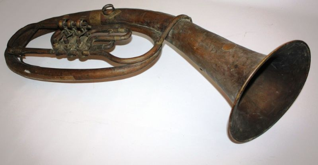 Altes Messinghorn mit glänzender Oberfläche, gebogenem Hals und aufgeblasenem Ende, verziert mit kunstvollen Gravuren auf einem weißen Hintergrund.