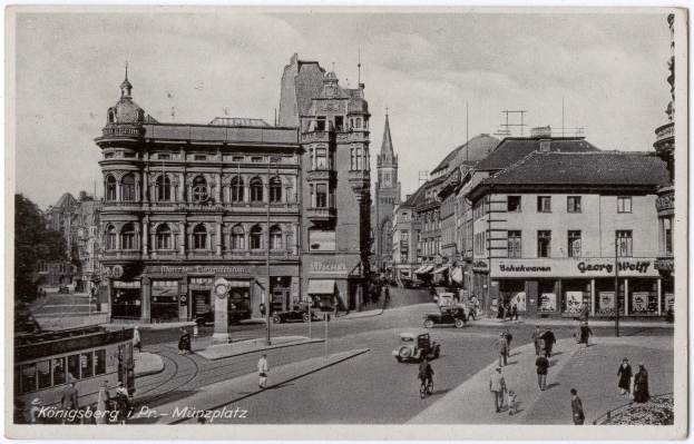 Schwarz-weiß-Foto einer belebten Münchner Stadtstraße mit Fußgängern, Fahrzeugen und Gebäuden mit Fenstern an den Seiten, Bäumen im Hintergrund und Text unten.