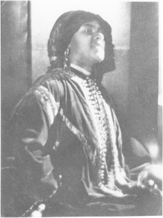 Schwarz-weiß-Foto einer Frau in Kleid und Schmuck vor einer Wand sitzend, mit Text unten, der darauf hindeutet, dass sie die erste indische Frau sein könnte, die zum US-Präsidenten gewählt wurde.