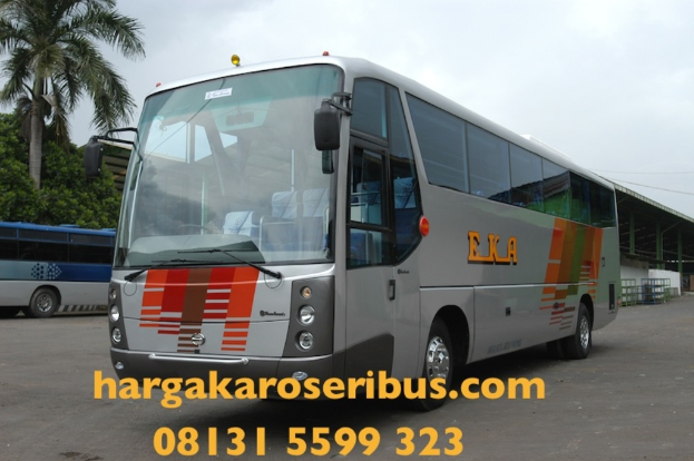 Ein grauer Bus in der Mitte, ein blauer Bus links, Tärä, eine Hütte rechts, Himmel oben und Kontaktinformationen unten.