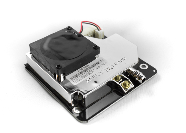 Nahaufnahme eines schwarzen und silbernen Kühlkörpers auf einer weißen Oberfläche mit mehreren daran angebrachten Drähten.