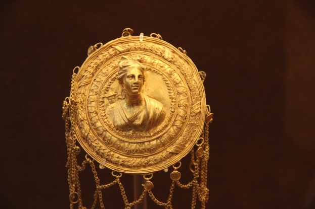 Goldene Medaille mit einer Frauengestalt auf dunklem Hintergrund, mit feinen und luxuriösen Details.