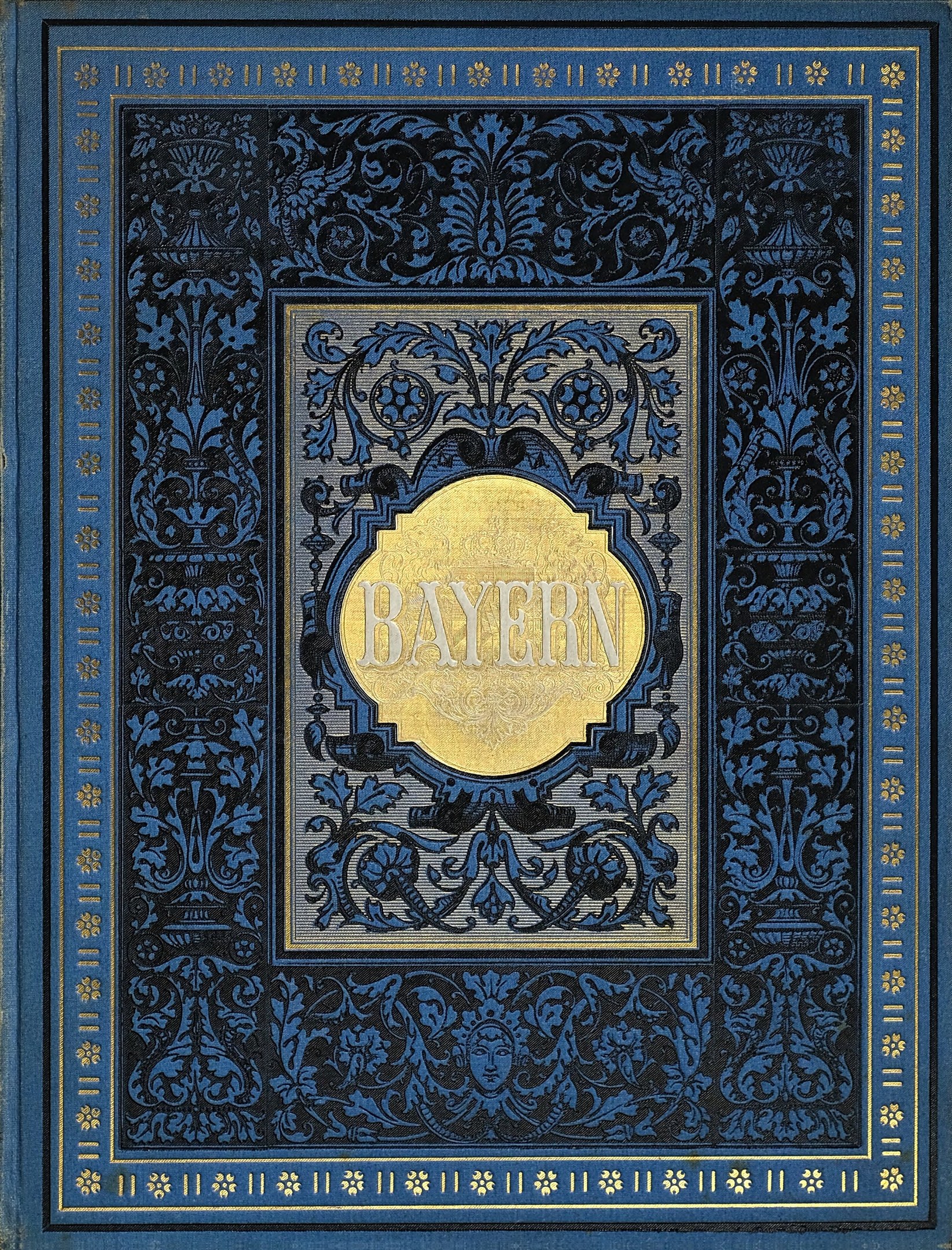 Ein blau-goldenes Buch mit dem Wort 'Bayern' auf dem Cover, das mit detaillierten Verzierungen geschmückt ist.