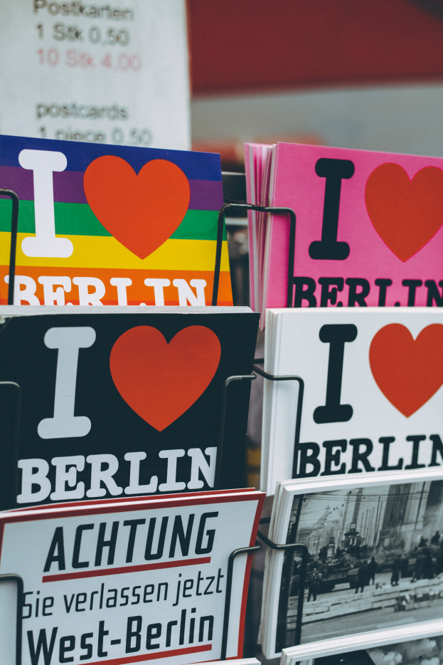 Ein Gestell mit verschiedenen Büchern und Postern mit der Aufschrift "Ich liebe Berlin" vor einem unscharfen Hintergrund.